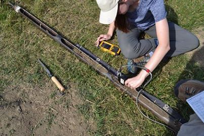 La doctorante Autumn Acree analysant le sol à l’aide d’un analyseur XRF à main Vanta en Roumanie.