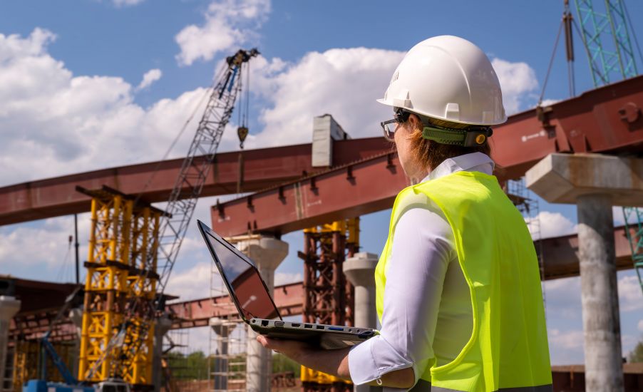 Kobieta-inżynier nadzorująca budowę stalowego mostu